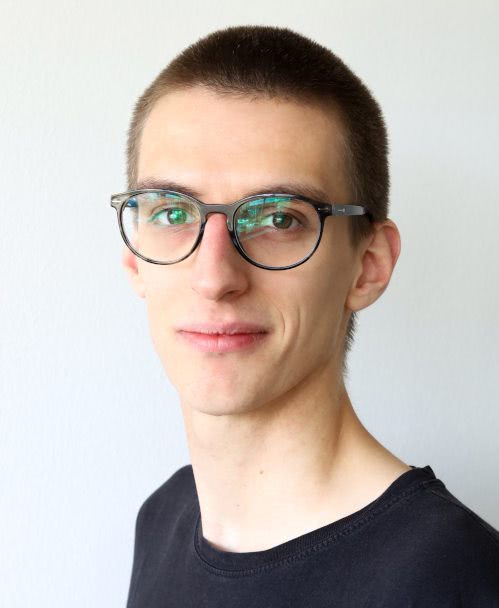 A portrait photo of Sören Tempel showing a white man with short dark hair and glasses